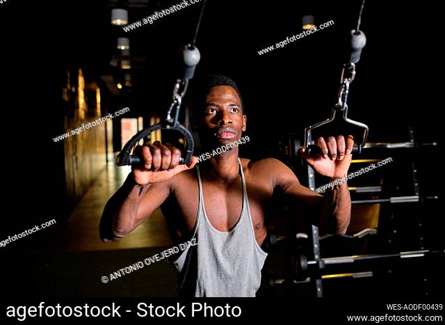African man practicing suspension training at gym