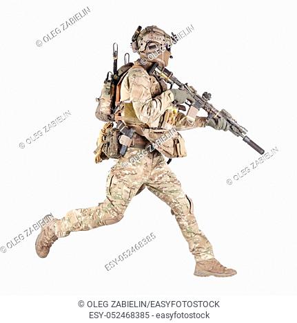Army soldier, equipped infantryman, airsoft player in camouflage battle uniform, helmet and tactical radio headset jumping