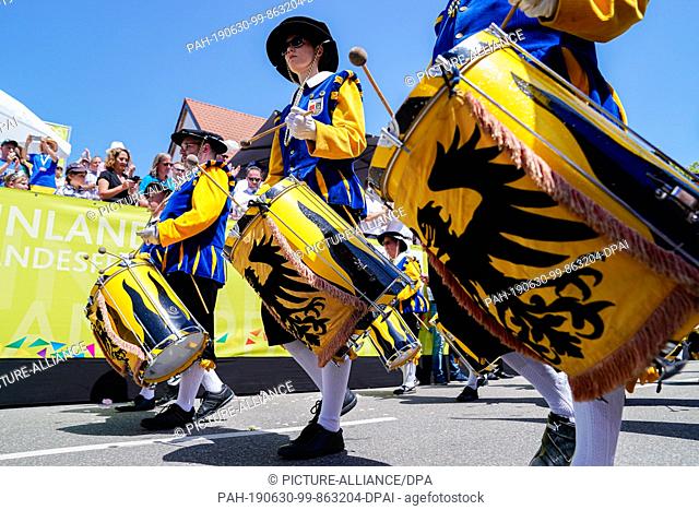 30 June 2019, Rhineland-Palatinate, Annweiler: A music group from the host city of Annweiler will pass by the grandstand during the procession at the end of the...