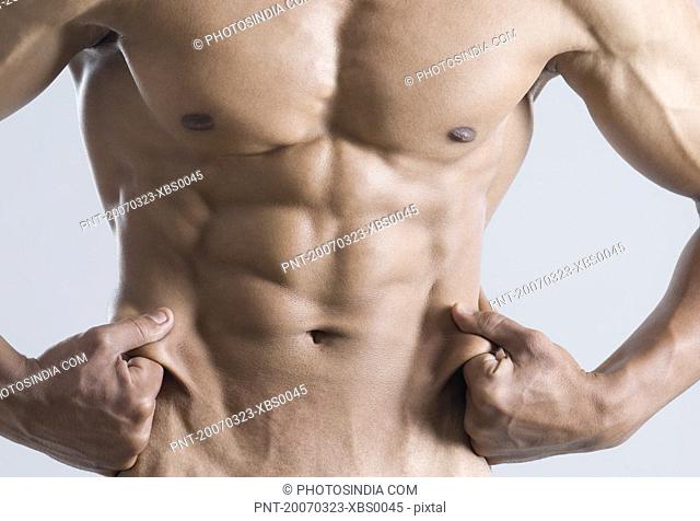 Mid section view of a young man showing his abdominal muscles