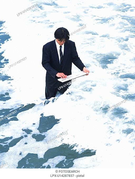 Image of a Businessman Typing With a Keyboard in the Middle of the Sea, High Angle View