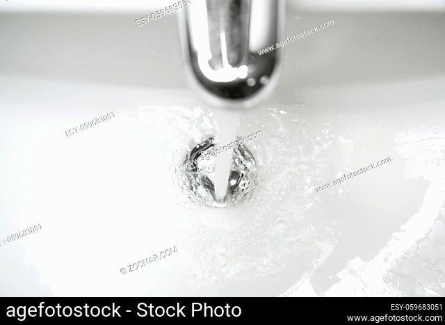 bathroom sink or hand basin with running water - close-up with shallow depth of field and motion blur