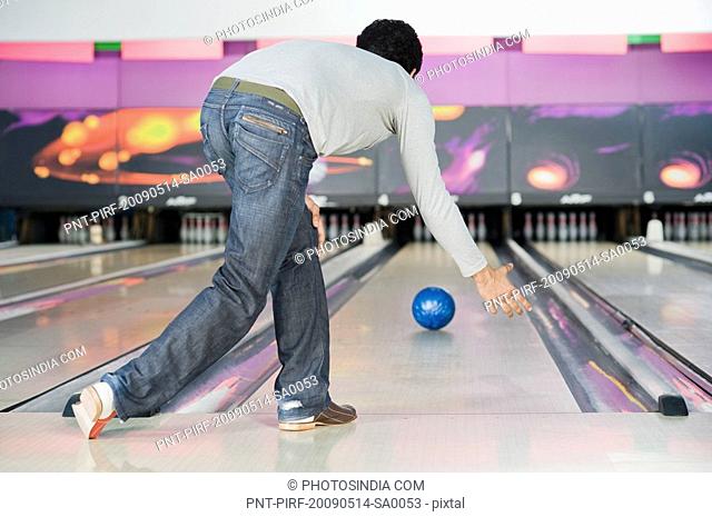 Young man playing ten pin bowling