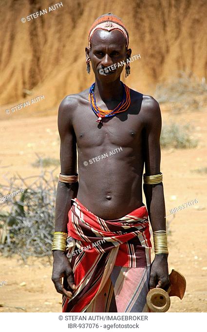 Colourfully decorated man with bare upper body in the dry savanna, Jinka, Ethiopia, Africa