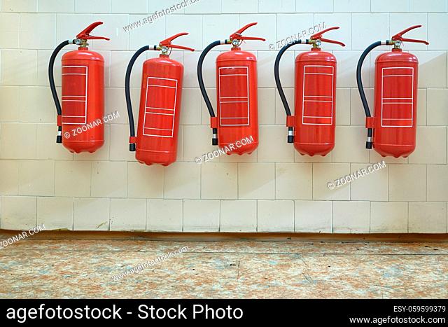 Many fire extinguishers mounted on the wall