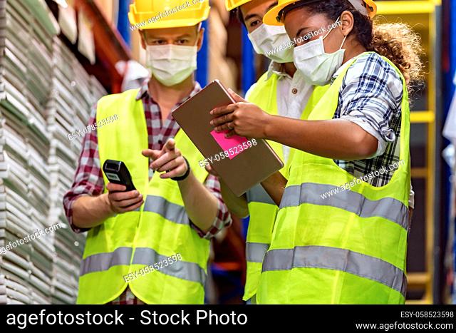 Interracial team Asian African Caucasian working on inventory use barcode scanner and digital tablet in distribution center