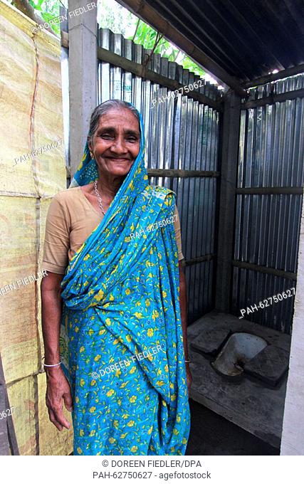 Anwara Begum, a grand mother, stands in front of her newly built toilet in the courtyard of her hut in the village of Outpara in Bangladesh, 8 April 2015