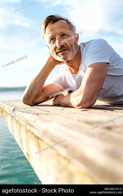 Mature man lying and looking at view from pier