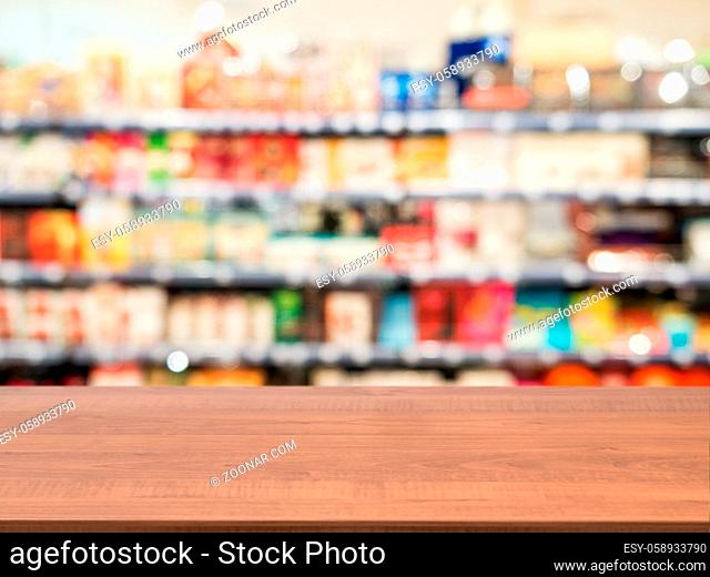 Wooden board empty table in front of blurred background. Perspective dark wood over blur in supermarket - can be used for display or montage your products