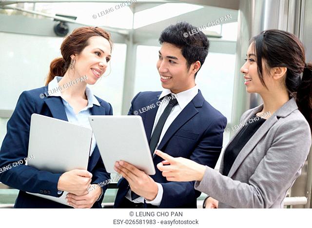 Group of business people discuss on tablet pc