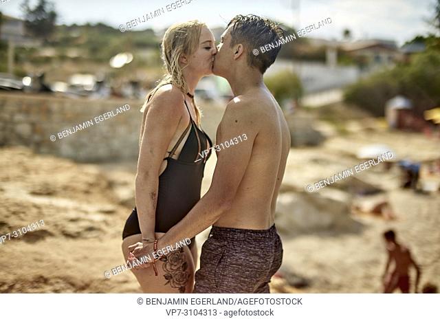 Greece, Crete, Chersonissos, couple in swimwear at beach, kissing, love, relationship, holiday, lovers