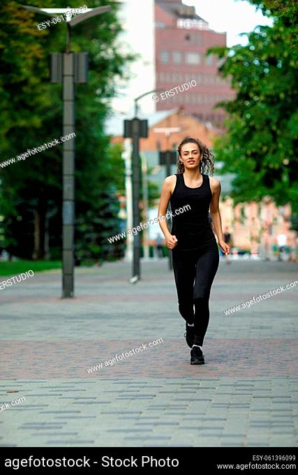 young attractive woman running in summer park