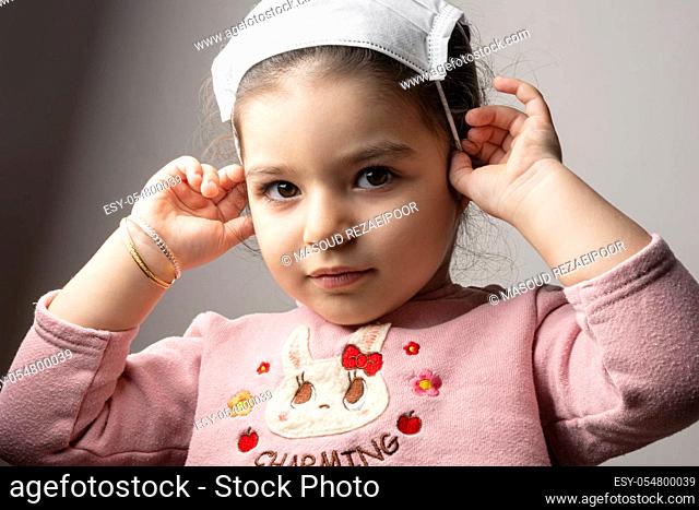 Little girl portrait with medical mask on her head, epidemic coronavirus outbreak concept