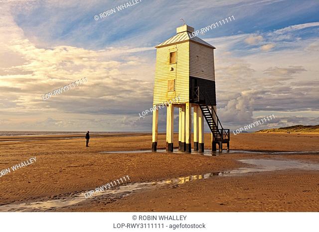 England, Somerset, Burnham-On-Sea. A man standing on the beach looking at Burnham-on-Sea Low Lighthouse, built by Joseph Nelson in 1832