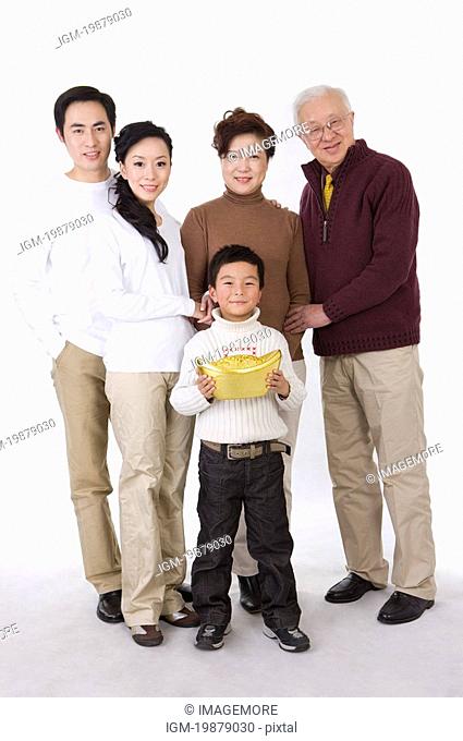 Family members holding a big gold ingot and smiling at the camera