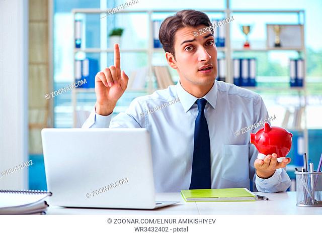 Businessman with piggy bank working in the office