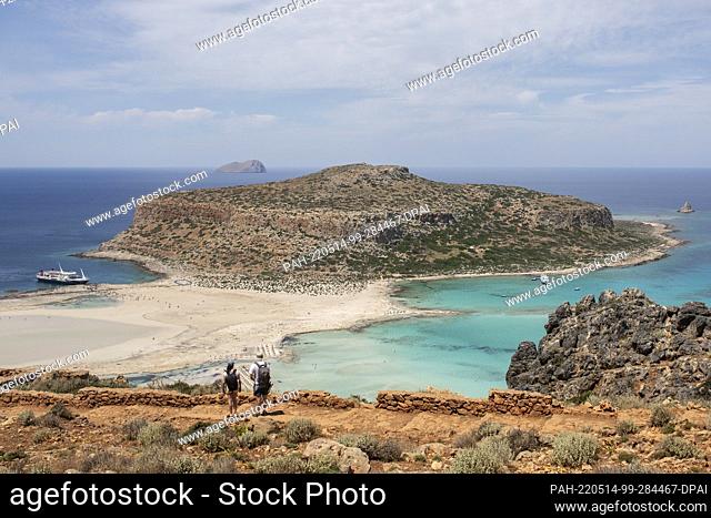 12 May 2022, Greece, Kissamos: Tourists walk along overlooking Balos beach and its lagoon in the northeastern part of the island of Crete