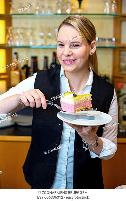 Waitress at café presenting cake on plate