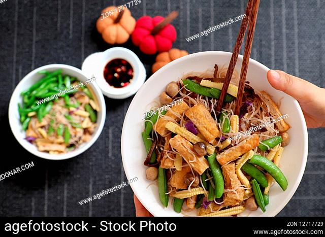 Dry rice vermicelli fried with vegetables from top view, a Vietnamese vegetarian dish for vegans, a dish can make quick for breakfast at home from noodle
