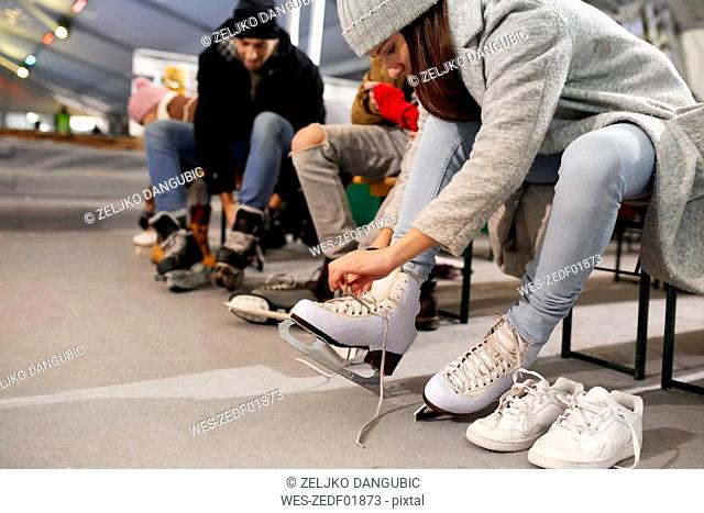 Friends putting on ice skates at an ice rink