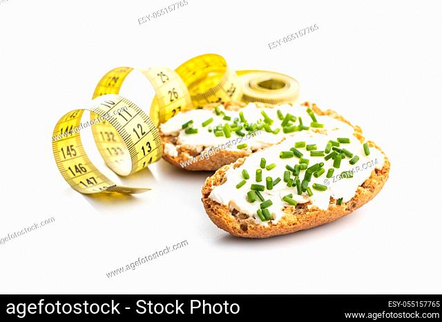 Cracker and measuring tape. Crispbread with creamy cheese and green chive. isolated on white background