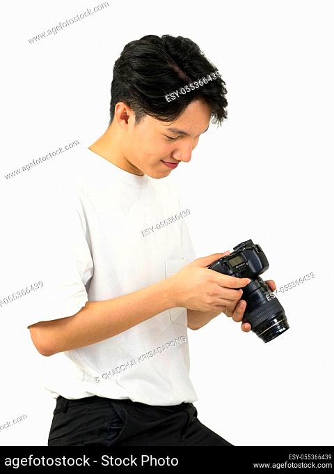 Asian photographers look at the pictures taken on the camera screen while standing in a white photography scene. The atmosphere in the photo studio