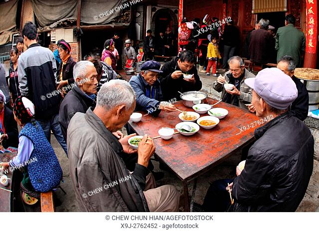 Family and friends having lunch togather for some celebration in Bei people's village in Dali, yunnan province, china