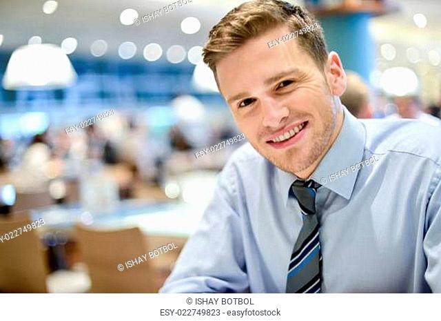 Smiling young man relaxing in restaurant