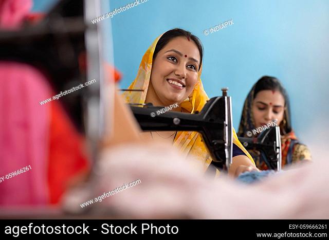 Two rural women working on sewing machines