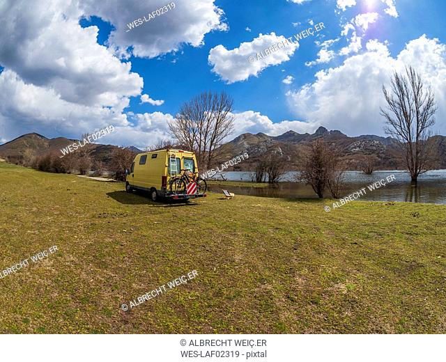 Spain, Asturias, Camposolillo, camper at Porma reservoir and Cantabrian Mountains in the back