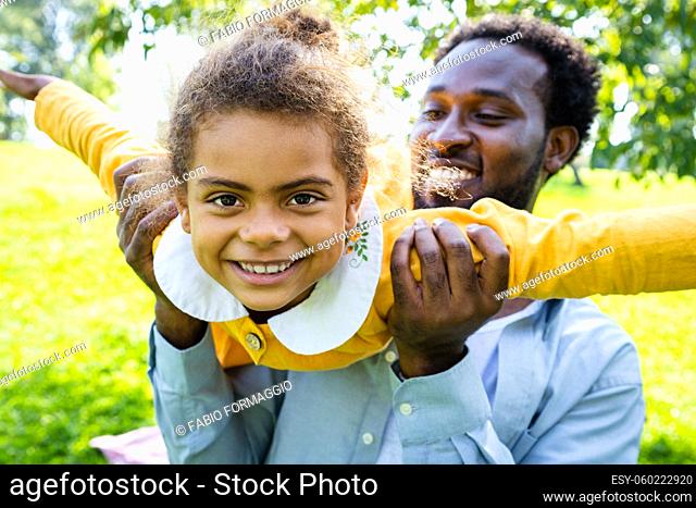 Beautiful happy african american family bonding at the park - Black family having fun outdoors, dad playing with his cute daughter