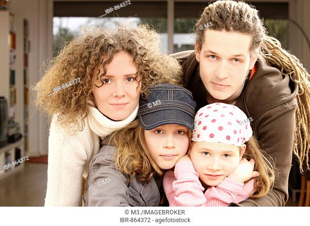 Family, all have long hair, looking into the camera