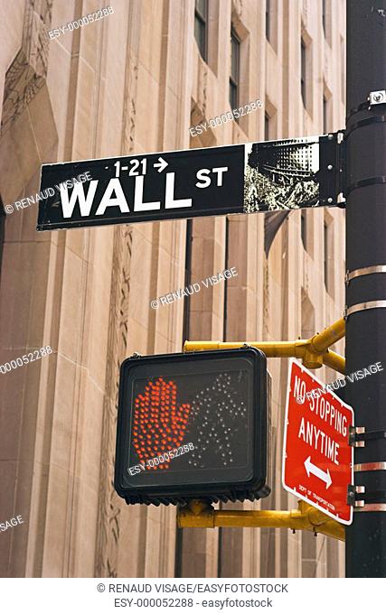 Street sign for Wall Street and pedestrian traffic signal. New York City. New York. United States