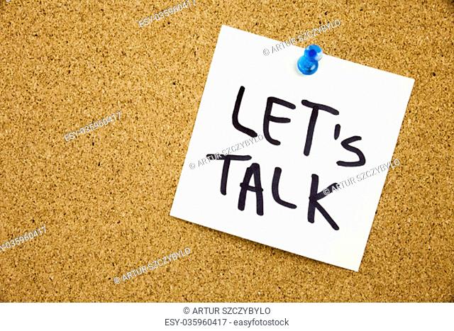 Phrase LET'S TALK in black ext on a sticky note pinned to a cork notice board