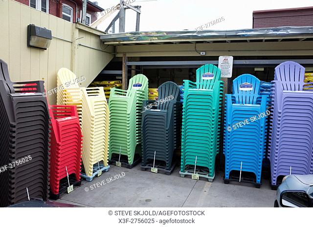 Array stacks of multicolored plastic Adirondack like summer lawn deck patio backyard chairs waiting. St Paul Minnesota MN USA