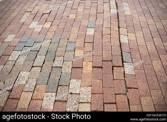 Stonework made of red cobblestones. Details of road. Tiles are laid in pedestrian zone