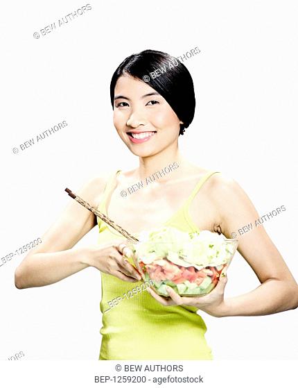 Teenage girl making salad