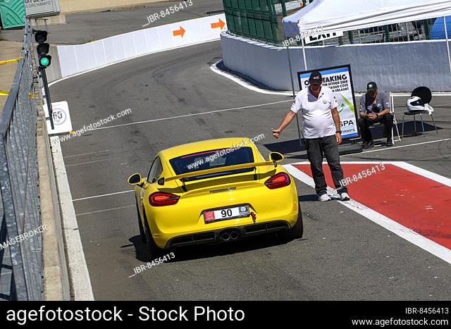 Race car Sports car Porsche Cayman GT4 at trackday gets green light from traffic lights Clearance from race marshal for exit from pit lane Pit lane on circuit...