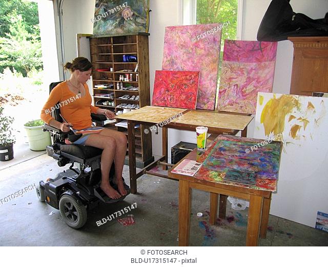 Young artist (female wheelchair user) enters her studio