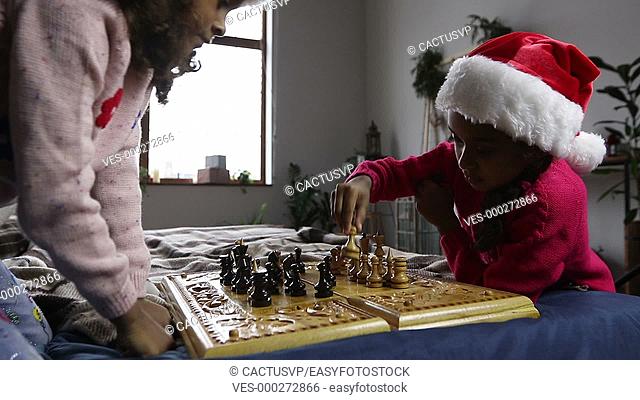 Two smart girls moving chess pieces on chessboard