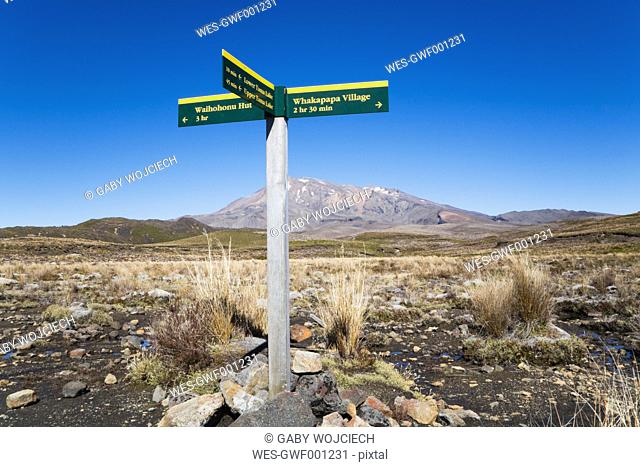 New Zealand, North Island, Hiking trail sign in tongariro national park and mount ruapehu in background