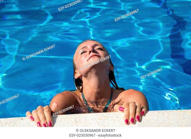 Sexy girl in bikini swimms in swimming pool