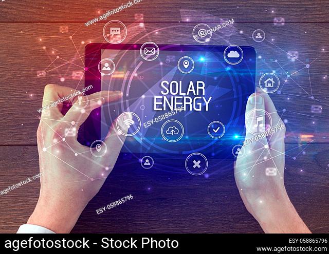 Close-up of a tablet with SOLAR ENERGY inscription, innovative technology concept