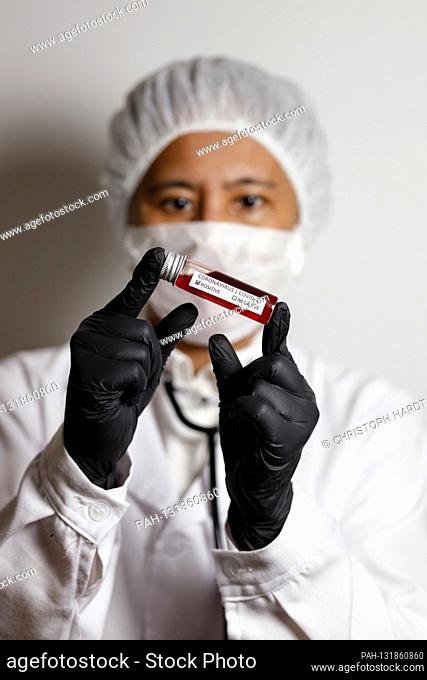 A virologist poses with a corona blood sample (Symbolto with Model) | usage worldwide. - Nuremberg/Bayern/Deutschland