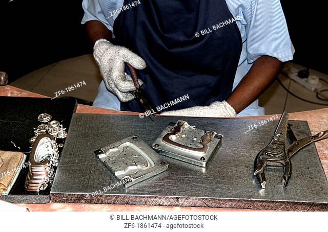 Worker taking hot product from mold in Pewter Factory called Royal Selangor in Kuala Lumpur Malaysia Asia