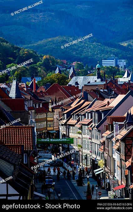 06 October 2020, Saxony-Anhalt, Wernigerode: The light-coloured facades of the half-timbered houses and the red roofs of the town stand out against the fading...