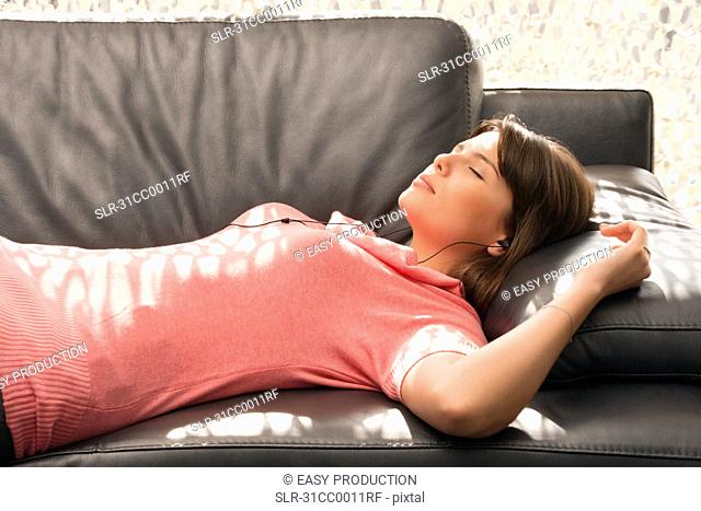 Woman relaxing on a sofa with headphones