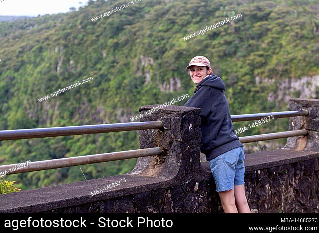 A young lady enjoying the panoramic view of Black River Gorges National Park, Gorges Viewpoint in Mauritius. It covers an area of 67