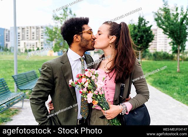 Business couple kissing each other at park