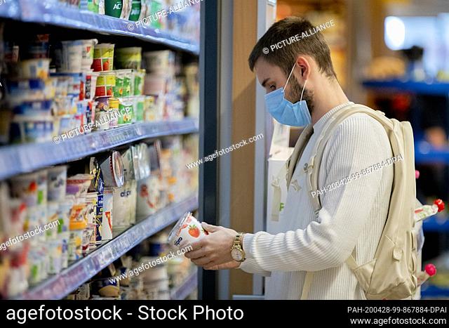 28 April 2020, Berlin: A customer is shopping in a supermarket in Berlin-Wilmersdorf with mouth and nose protection. Photo: Christoph Soeder/dpa